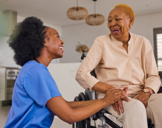 aide and elderly woman smiling while looking at the phone